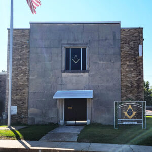 Multistory brick and granite structure with Masonic emblem and flagpole