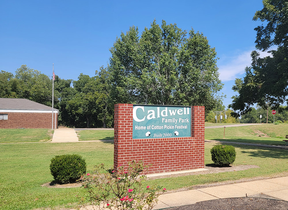 Sign saying "Caldwell Family Park Home of Cotton Pickin Festival Built 2000"