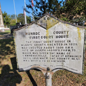 Metal sign with the history of the first courthouse in Monroe County