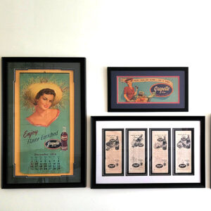 Framed advertisements for Grapette featuring women and soda bottles