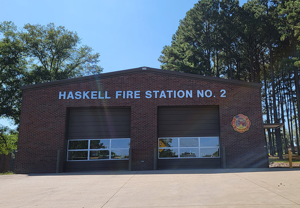 Red brick building with two garage bay doors and lettering saying "Haskell Fire Station Number Two"