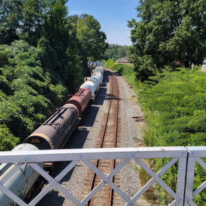 Long string of train cars on train tracks as seen from above