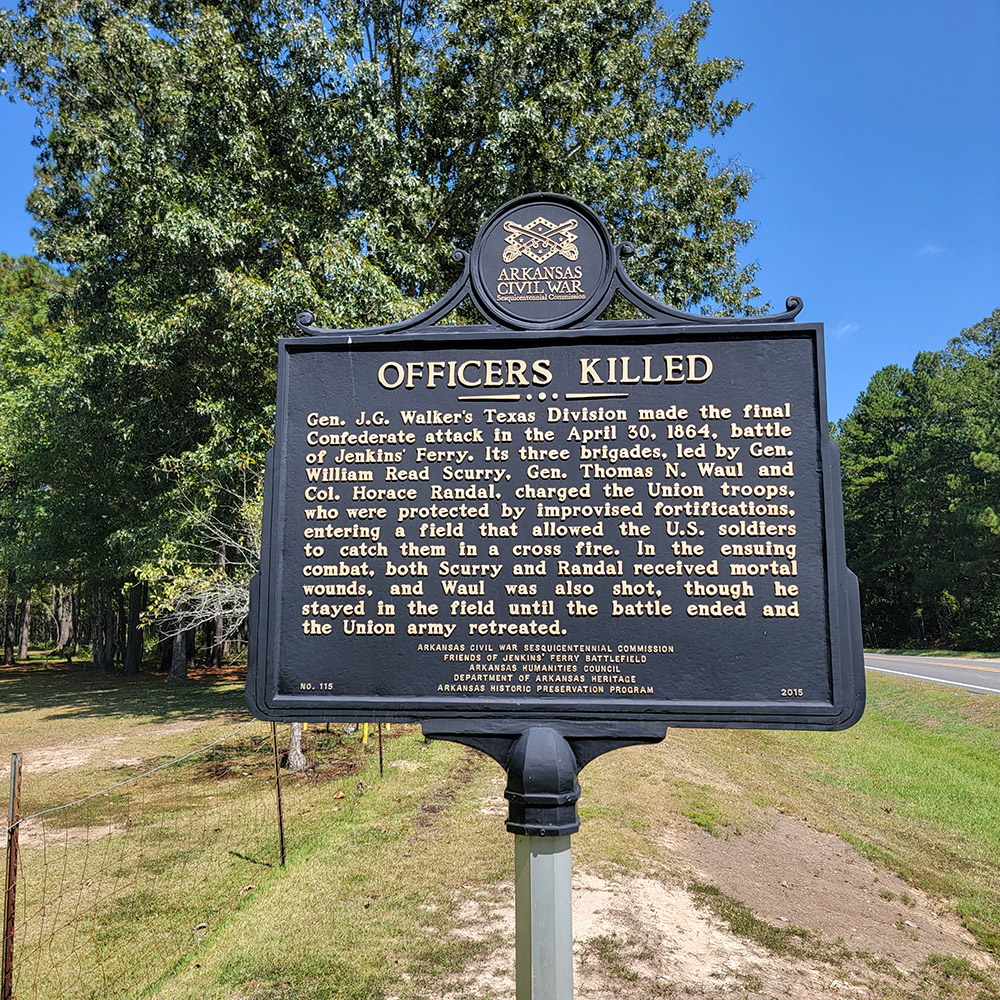 Metal sign with words about fallen officers and trees in background