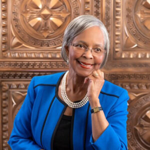 smiling black woman with gray hair and blue blazer