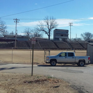 Stadium with bleachers and a pickup parked out front