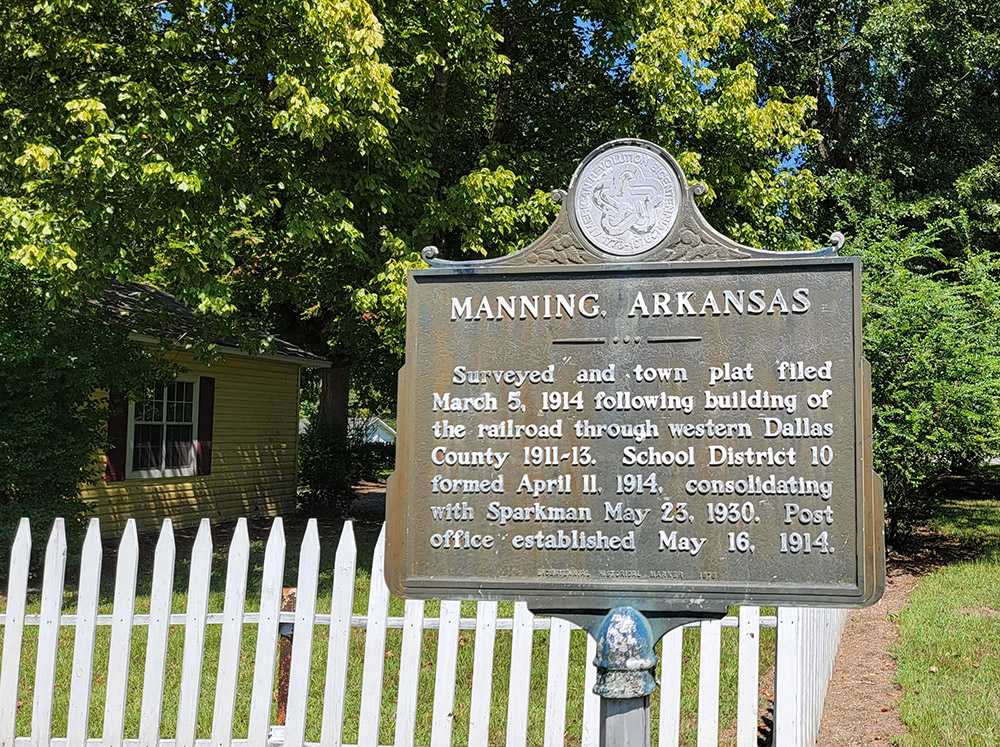 Historical sign about Manning with yellow house