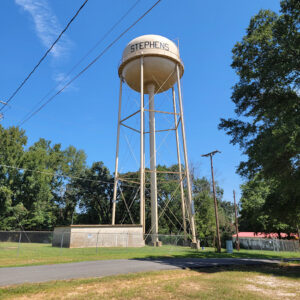 Tan metal water tower with "Stephens" on it