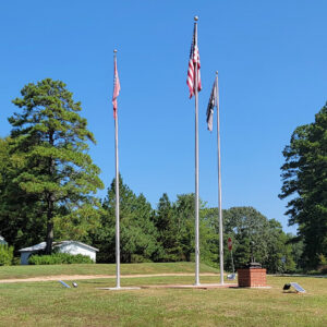 Three flag poles with flags