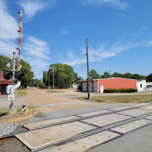 street with railroad crossing and a few business buildings