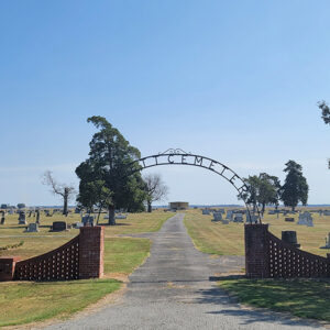 Cemetery with graves and two brick sections with an arch over the entrance saying "Gillett Cemetery"