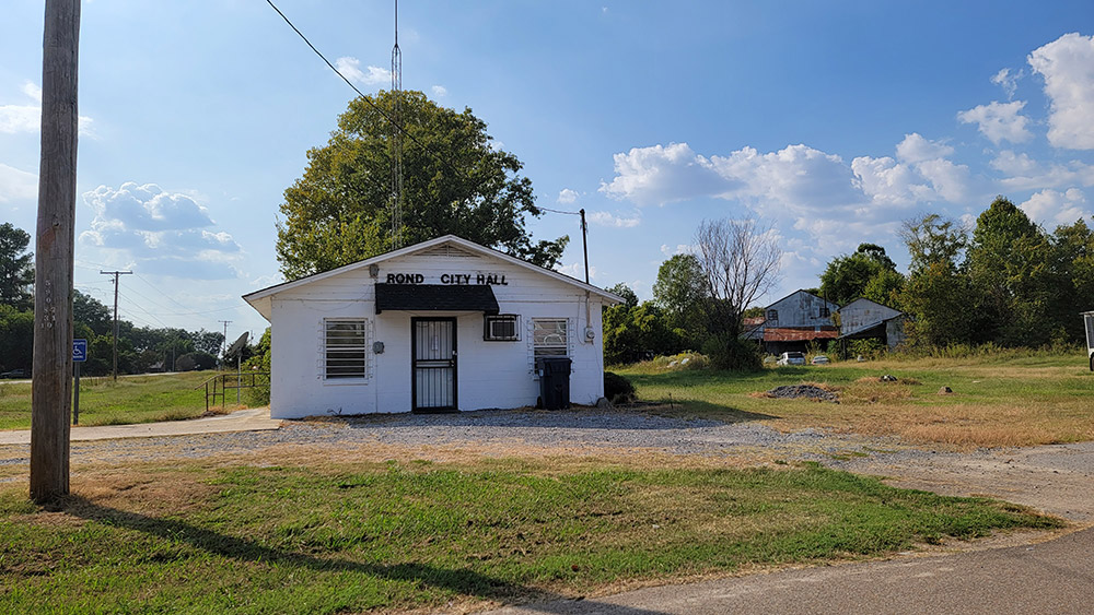 Single story white block building with lettering saying "Rondo City Hall"