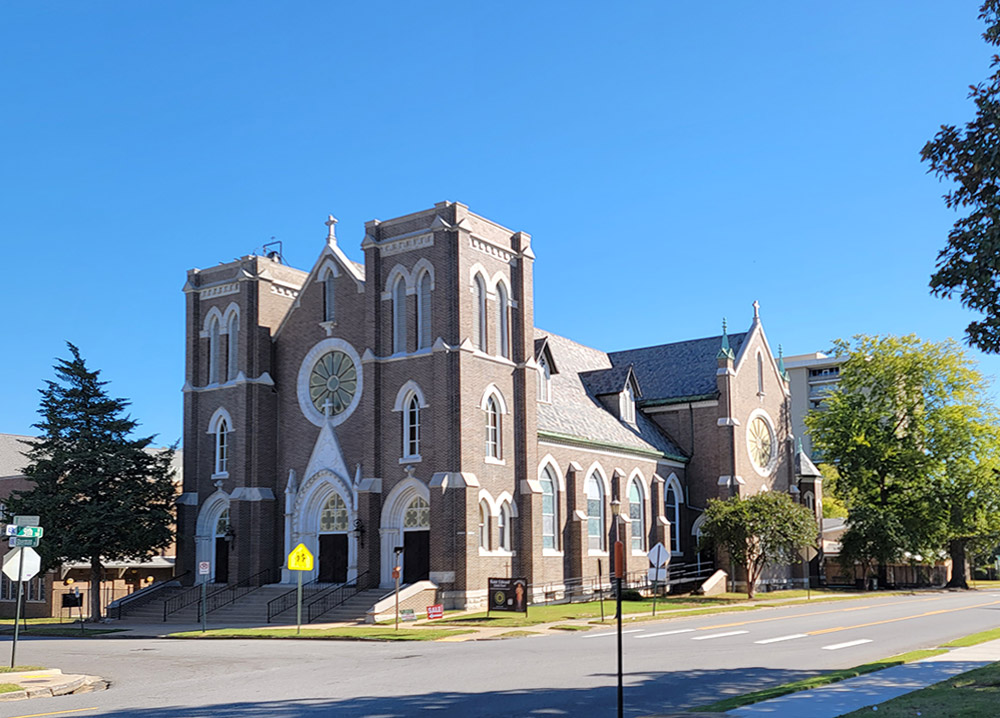 large multistory brown brick church building with ornate styling