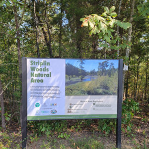 Sign about Striplin Woods Natural Area with photo of the natural area