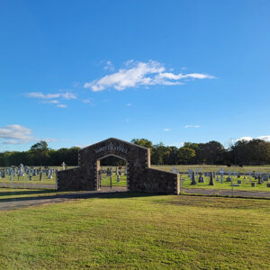 Cemetery with graves and a gate with a stone archway
