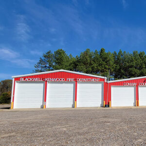 Single story red metal building with six garage doors