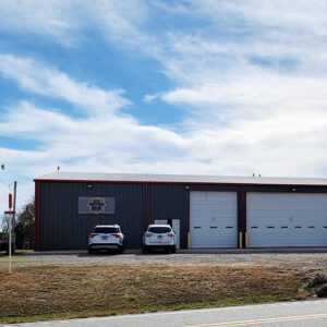 Single story metal fire department building with three garage doors