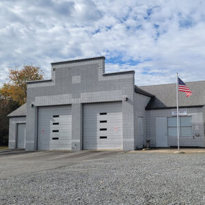 Gray brick fire department building with two garage doors