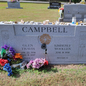 Gravestone for Glen Travis Campbell and Kimberly Woollen Campbell with rocks and small gifts on top