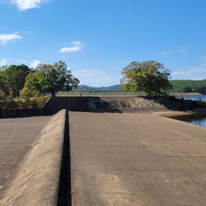 Concrete spillway on a lake with trees all around