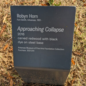 Sign with information about a sculpture called Approaching Collapse