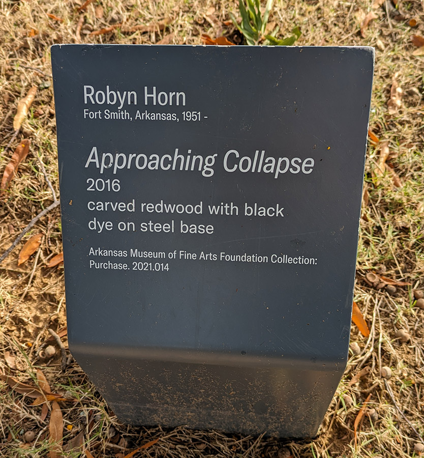 Sign with information about a sculpture called Approaching Collapse