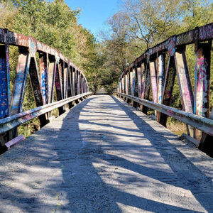 Metal bridge with colorful graffiti on side trusses