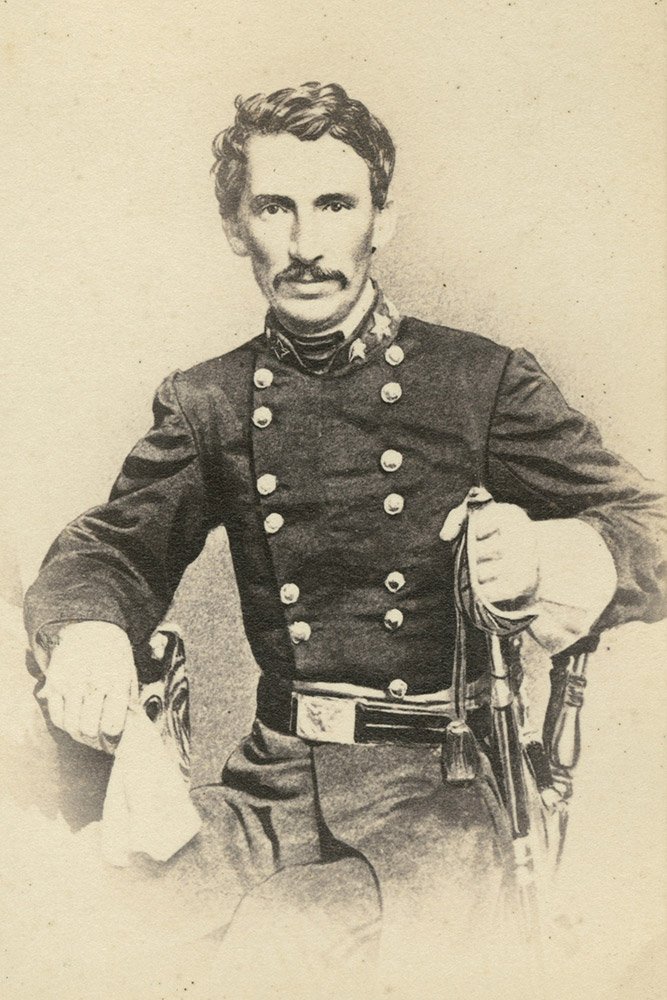 White man with mustache posing in military garb