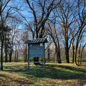Sign and picnic area amid trees
