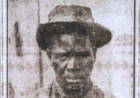 Newspaper photo of African American man wearing suspenders and hat