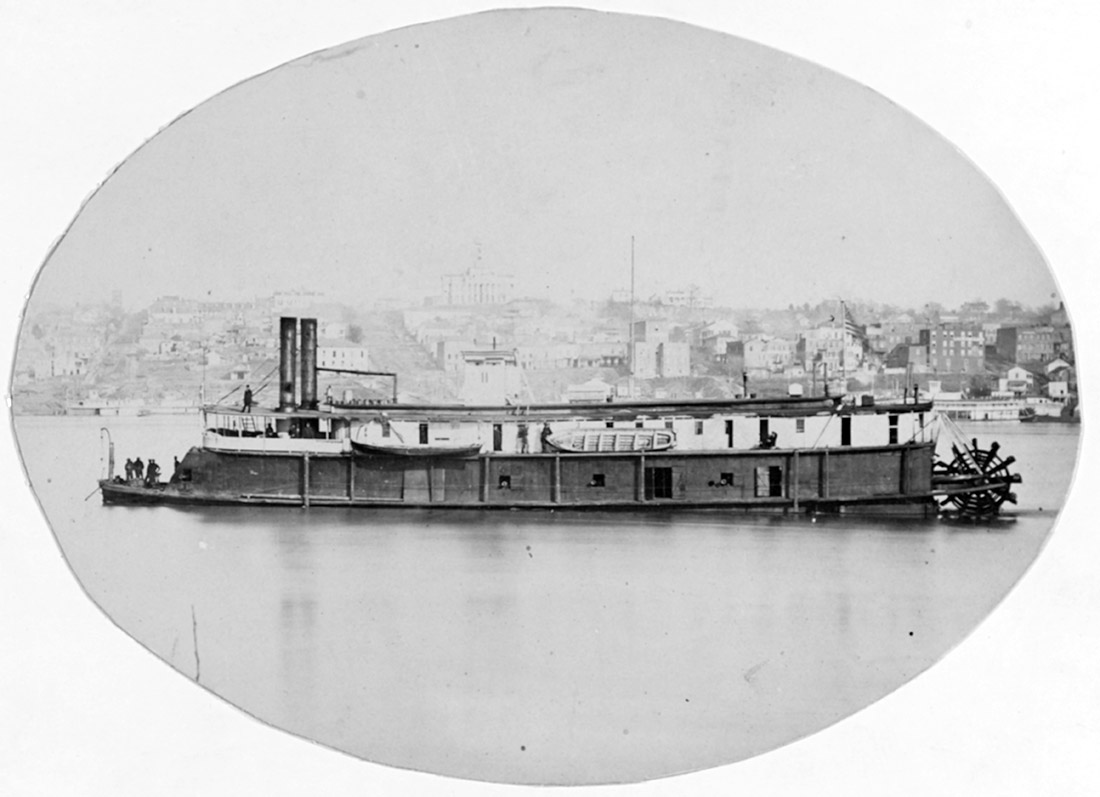 Paddlewheel boat on a river with city on shore