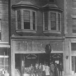 African American people standing in front of multistory brick storefront