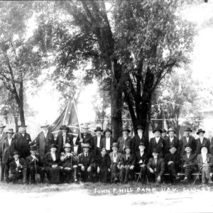Large group of older white men in hats sitting and standing