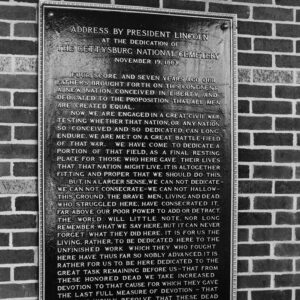 Plaque with words on it attached to brick wall