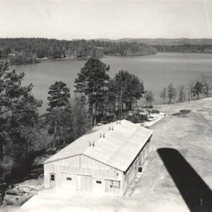 view from airplane of warehouse-type building with tree-lined lake behind it