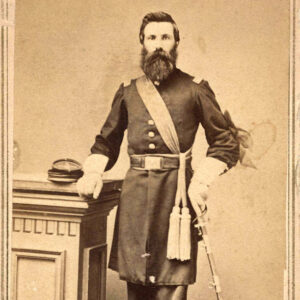 bearded white man in military garb standing by column