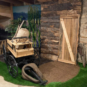 Some farm equipment and corn stalks in a museum display