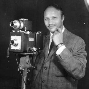 African American man in suit standing by camera