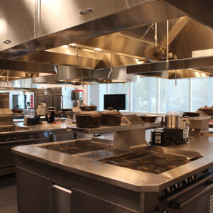 Interior of a large commercial kitchen with stainless steel appliances