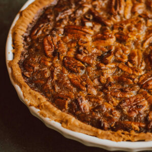 close up of a pie with pecans in it