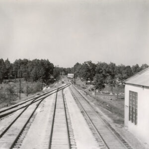 Three sets of railroad tracks running into the distance alongside depot building