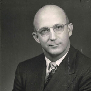 Balding white man in suit with glasses